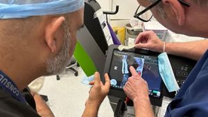 2 vets looking at an xray image in a surgical room